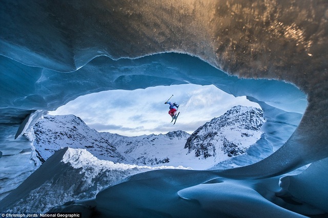 Place Pitztal Galcier, Austria. An athlete jumps near an ice cave in the Alps.