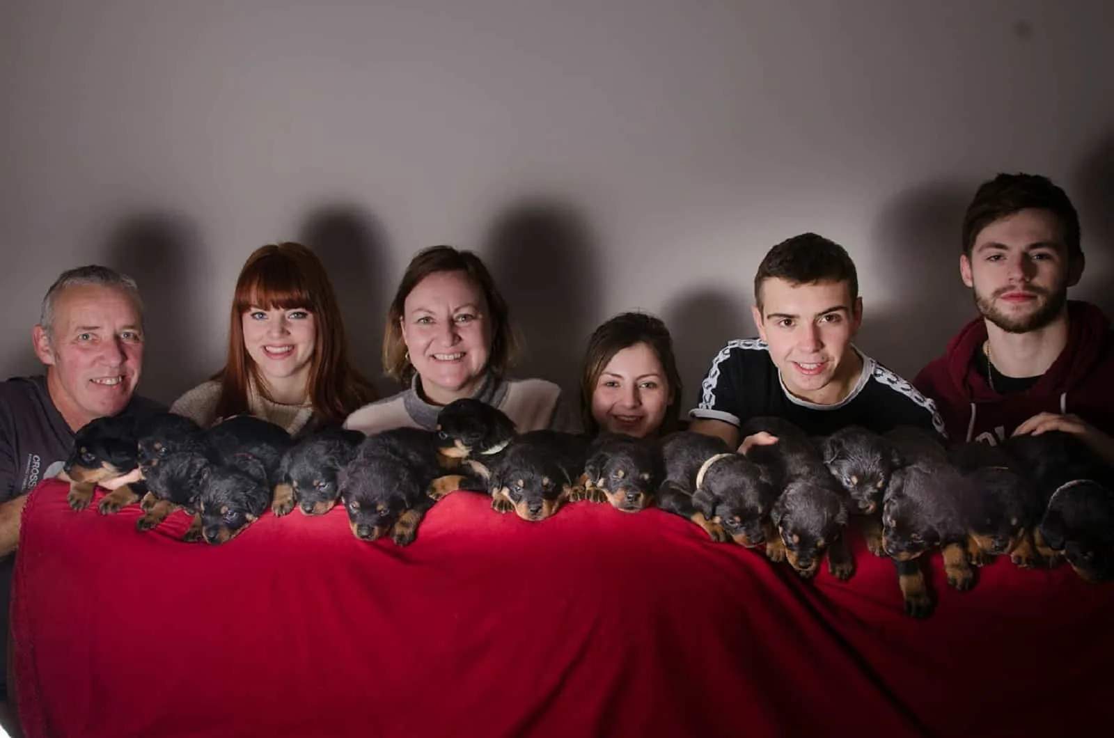 rottweiler puppies and smiling people posing for photography